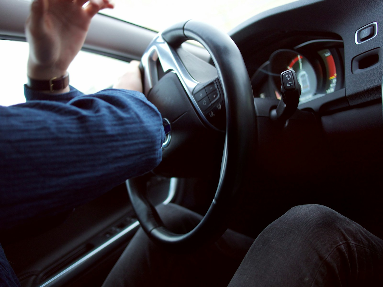 man holding black steering wheel auto